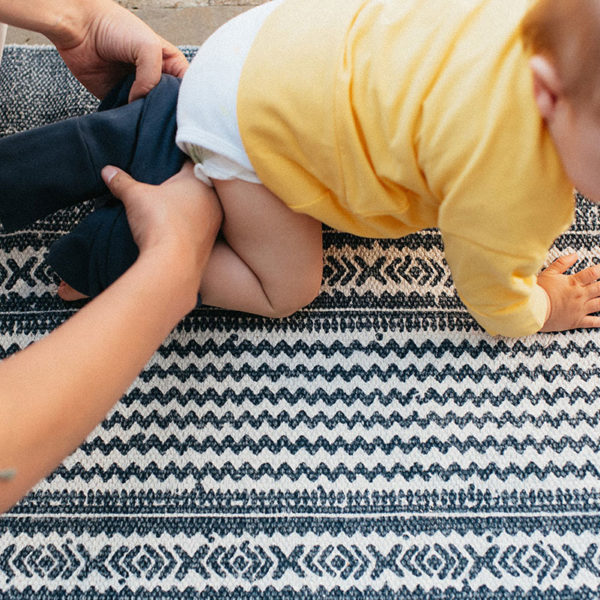 Bébé avec un t-shirt évolutif jaune et un pantalon évolutif bleu marine